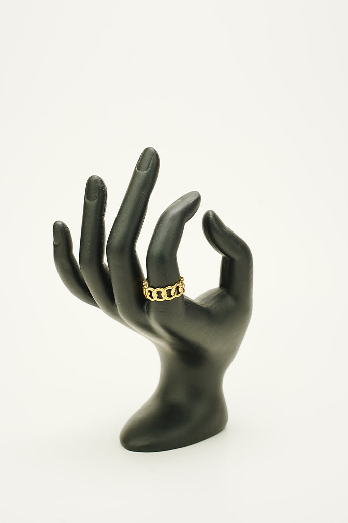 Golden Tranquility Ring resting on dark hand model