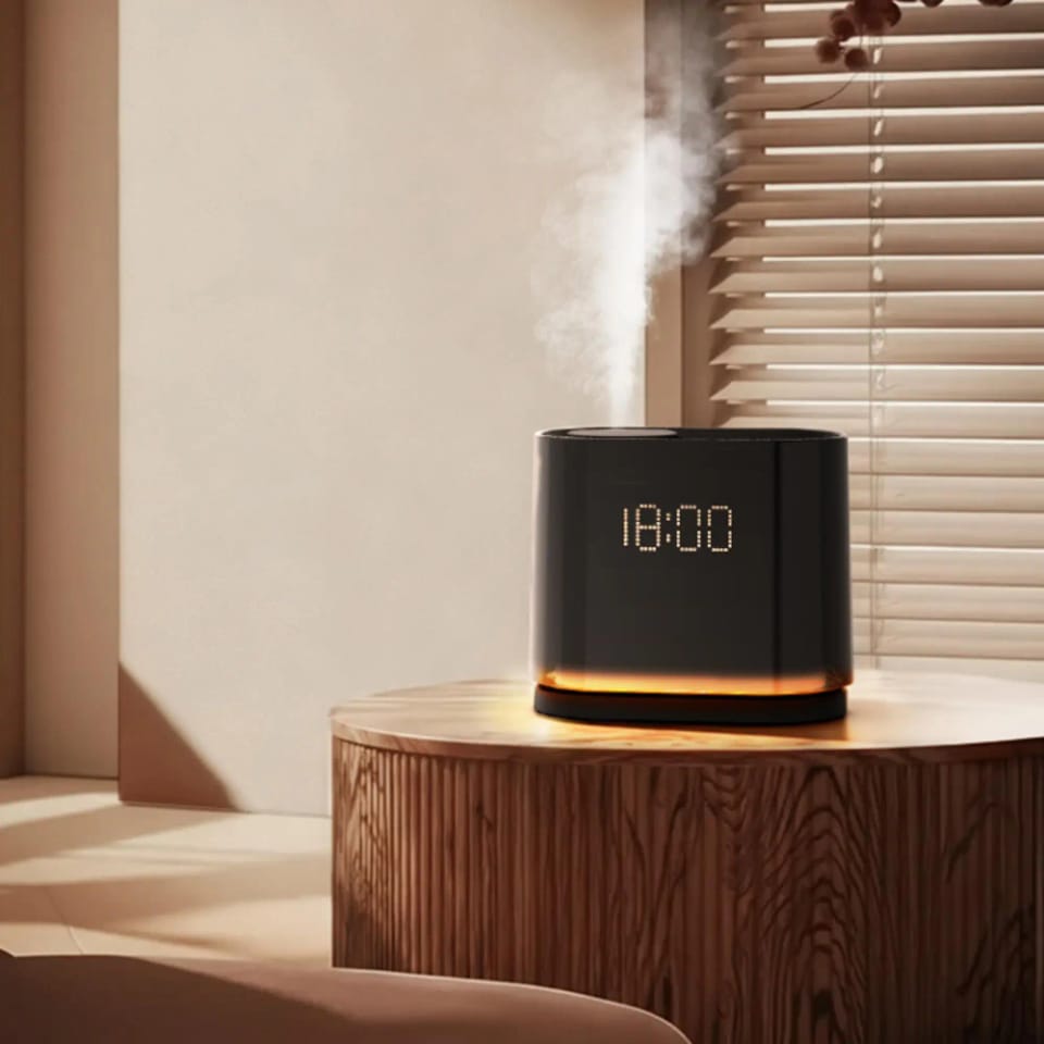 Digital clock aroma diffuser releasing mist on a wooden table in a living room