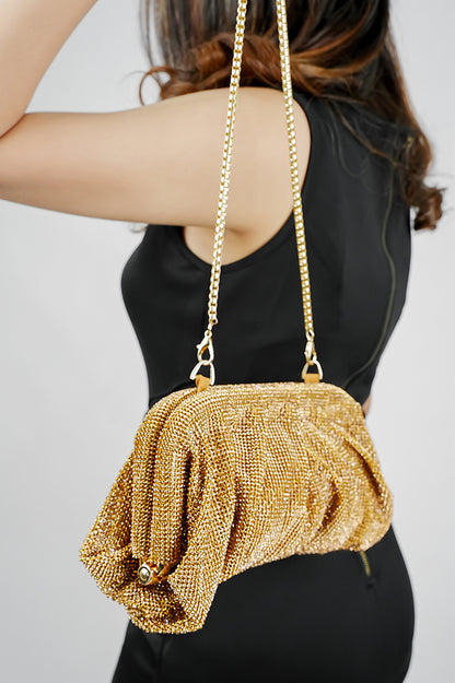 Gold clutch bag for women carried by the matching chain, side view