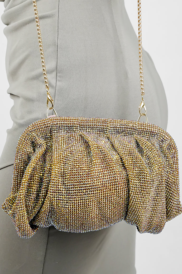 Shimmer clutch bag for women with matching chain, held against a grey dress