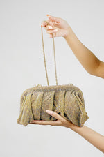 Shimmer Benedetta clutch bag held in the hand with the chain hanging
