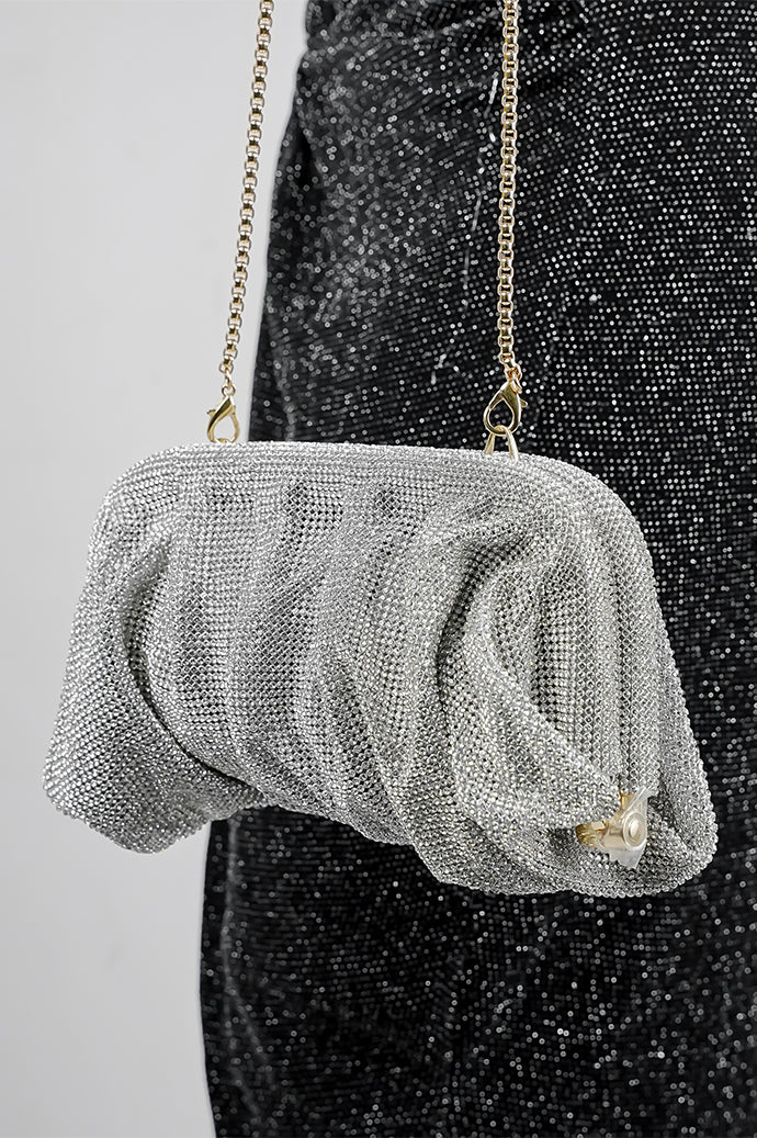 Silver Benedetta clutch bag held in front, showing the gathered shape
