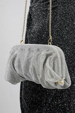 Silver Benedetta clutch bag held in front, showing the gathered shape