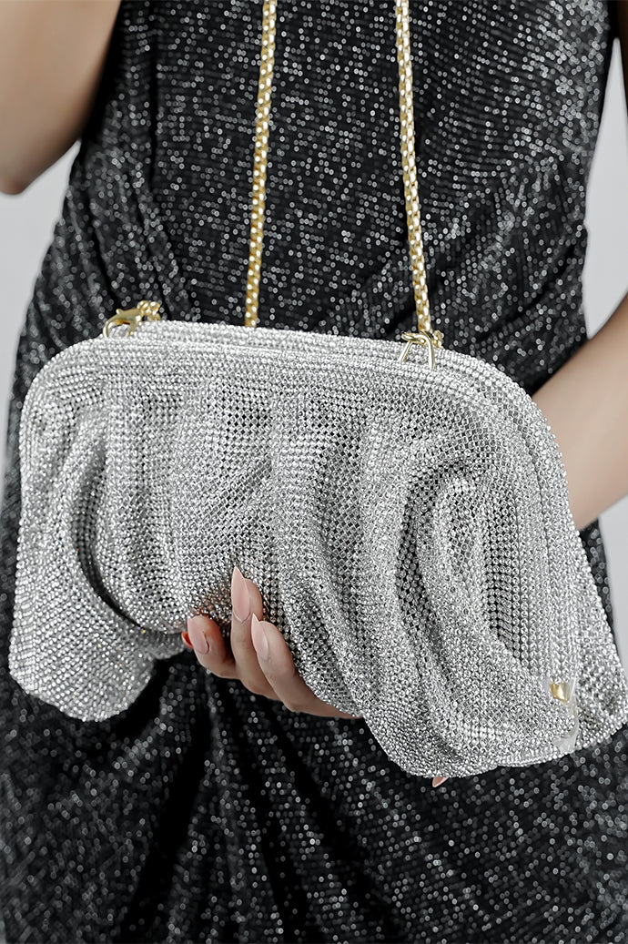 Silver Benedetta clutch bag held in the hand with the chain hanging