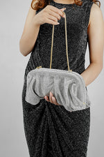Silver rhinestone mesh clutch bag held close, showing the gathered front