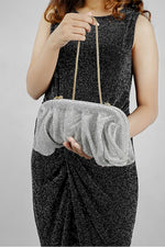 Woman holding a silver Benedetta clutch bag at the waist with a dark dress