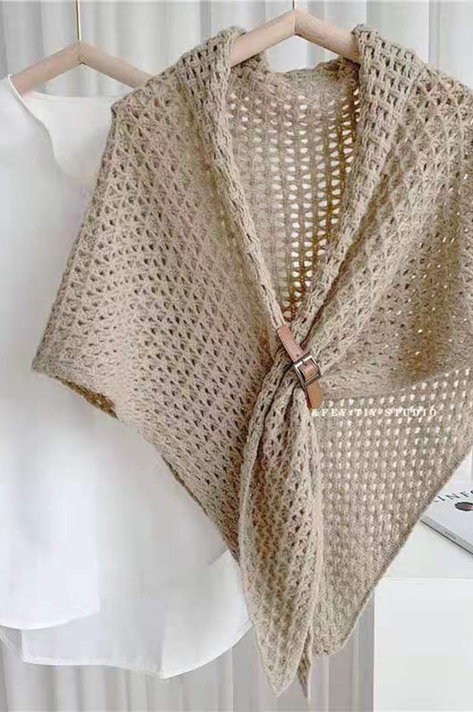 Bohemian open-knit winter cape for women in taupe with a tan toggle fastener, on a hanger