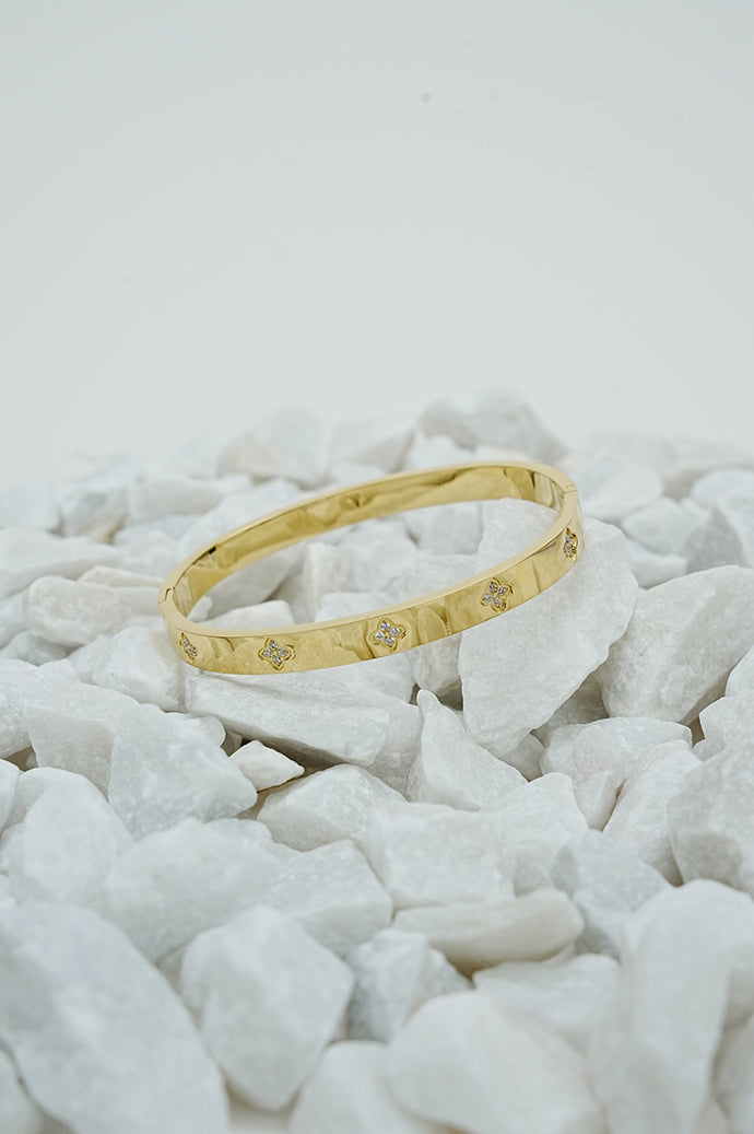 Gold clove stone bangle for women on white stones