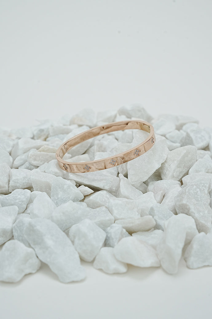 Rose gold clove stone bangle for women on white stones