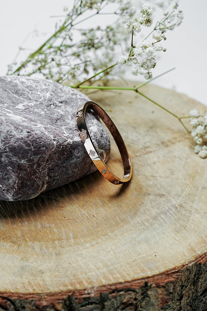 Side view of gold clove stone bangle with stone detail