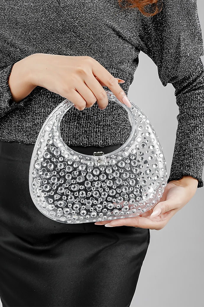 Woman holding a clear clutch bag in both hands at waist level