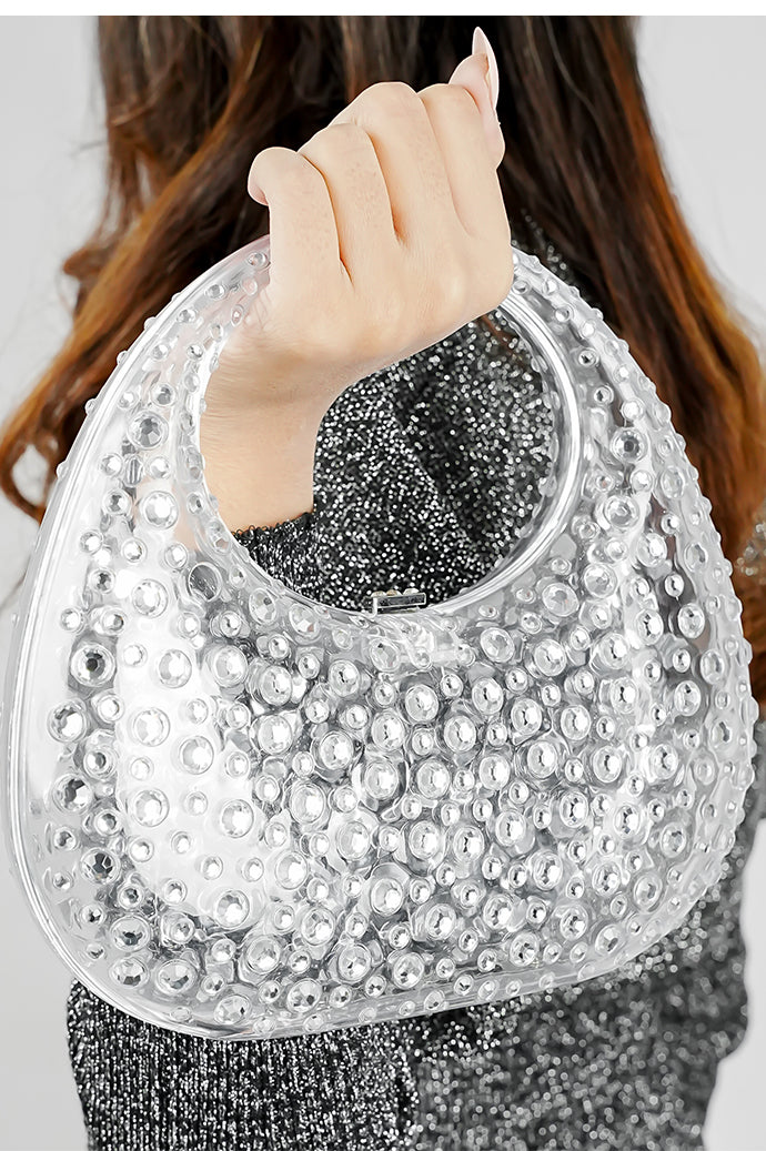 Close-up of a clear textured clutch bag lifted by the handle