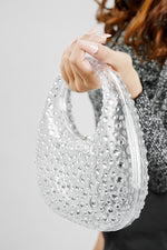 Clear clutch bag for women held up, angled view of the textured finish