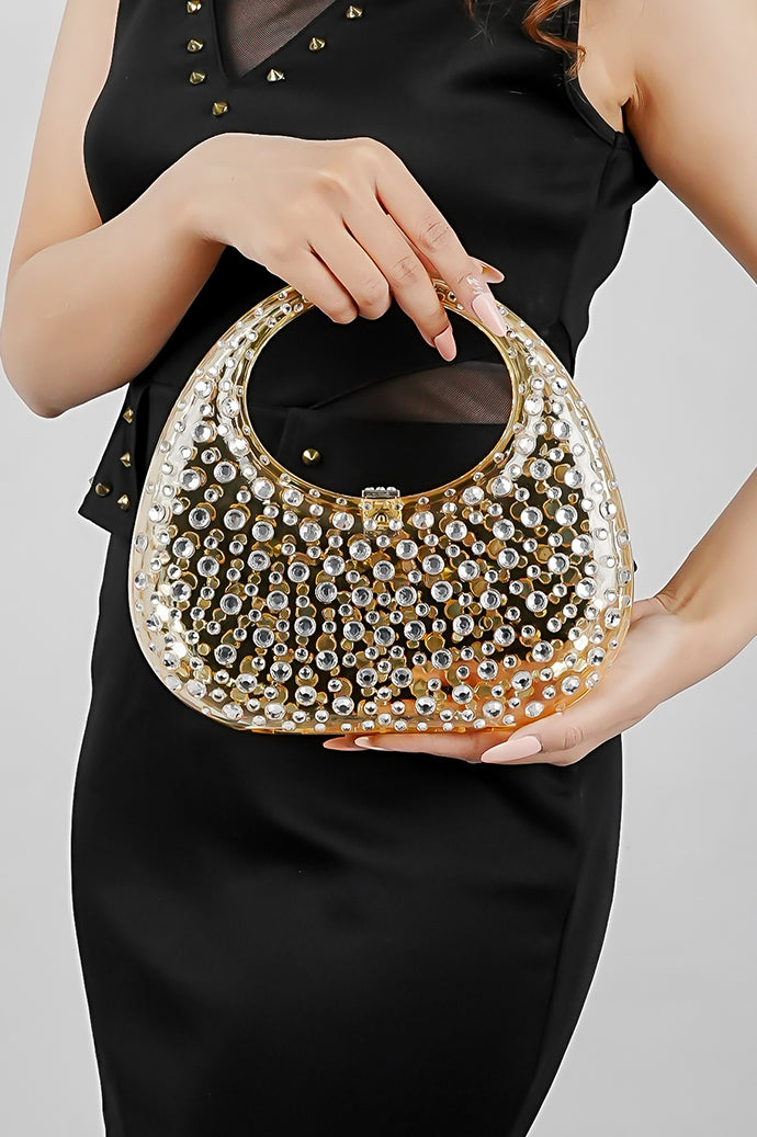 Woman holding a gold clutch bag in both hands, front view