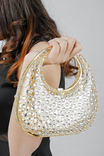 Gold clutch bag for women lifted by the handle, side view