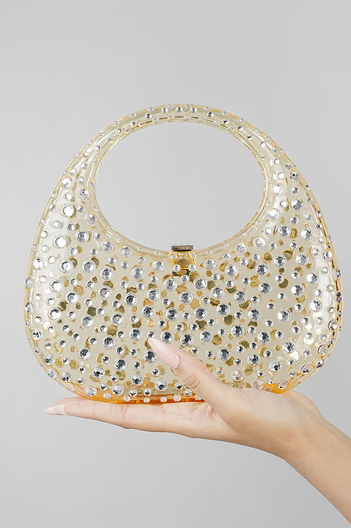 Gold clutch bag for women resting in the hand, front view with clasp