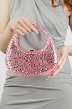 Pink clutch bag for women held by the handle with a grey dress