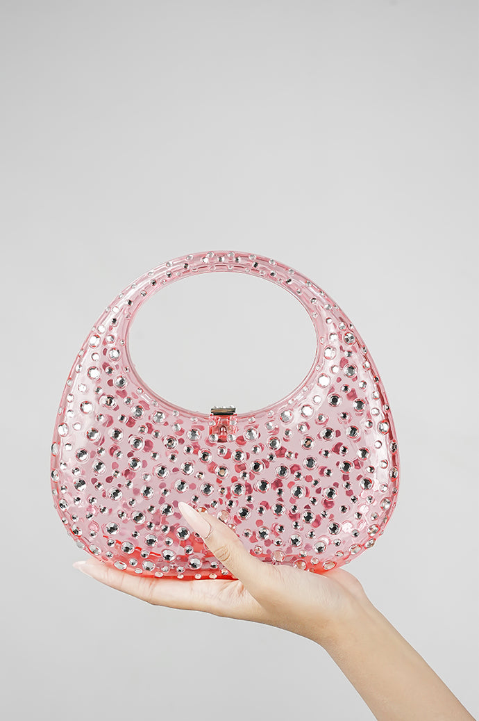 Pink clutch bag resting in the hand, front view with clasp