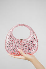 Pink clutch bag resting in the hand, front view with clasp
