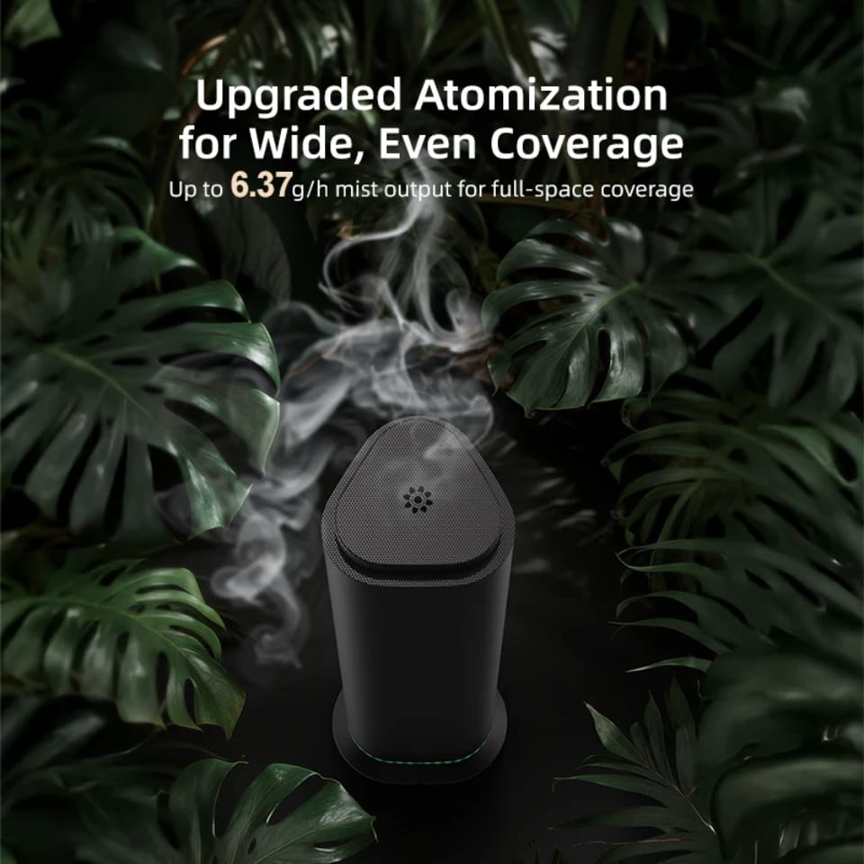 Black commercial aroma diffuser with two-fluid atomization mist among green leaves