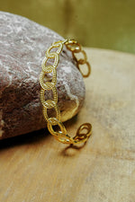 Close view of gold open chain-link bangle for women