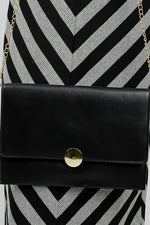 Close-up of the gold emblem on the black Envelope Bag