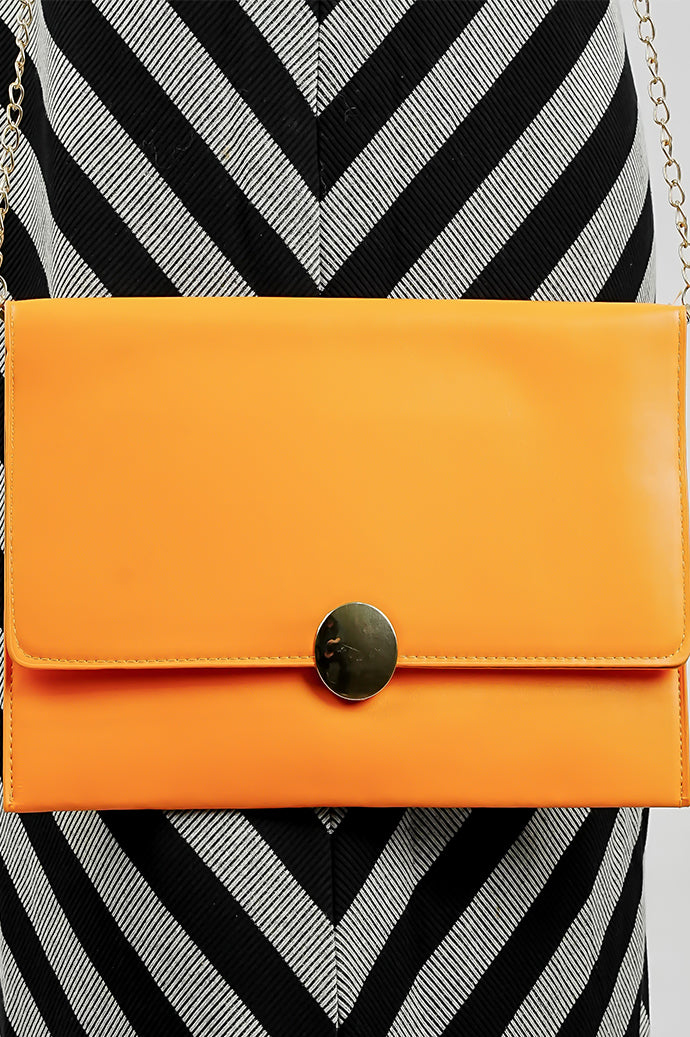 Close-up of the orange Envelope Bag with its gold emblem