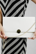 White Envelope Bag styled with a black and white striped dress