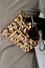 Close-up of the textured hammered effect on the gold clutch