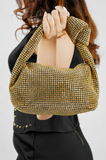 Hubo gold clutch carried by its knotted handle, front view