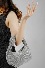 Hubo silver sparkling clutch styled with a black evening dress