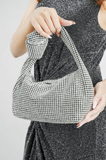 Hubo silver clutch carried by its knotted handle