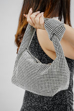 Hubo silver clutch with knotted handle, carried at the side