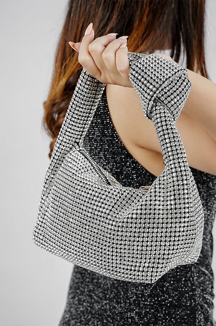 Hubo silver clutch with knotted handle, carried at the side