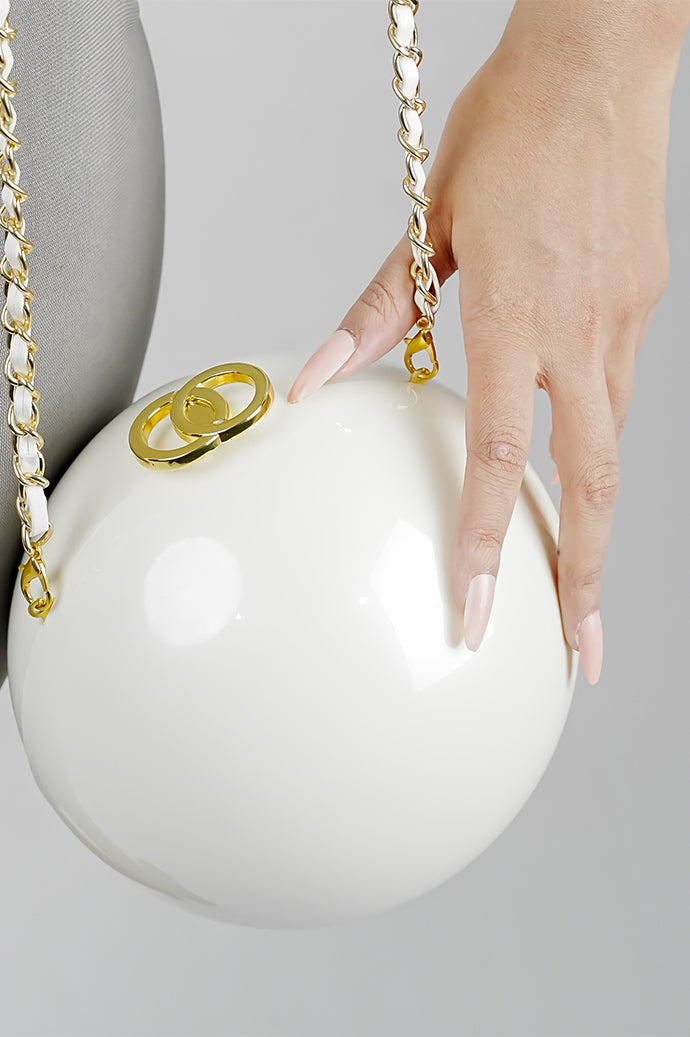 Close-up of the golden clasp on the Luna white globe clutch