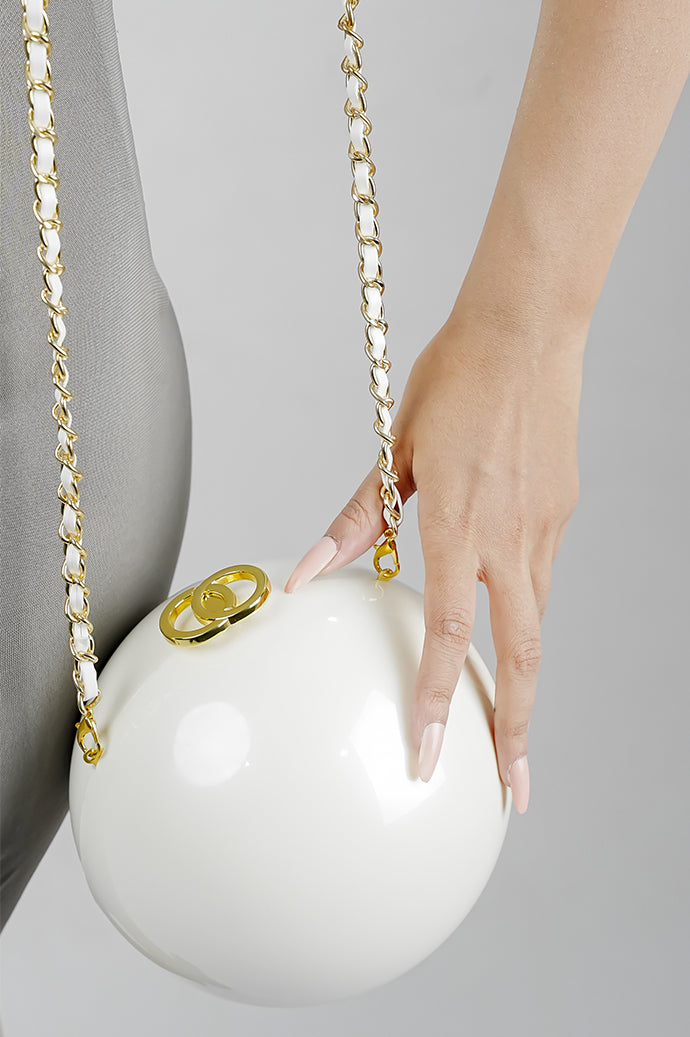 Luna white globe clutch with golden clasp and chain, side view