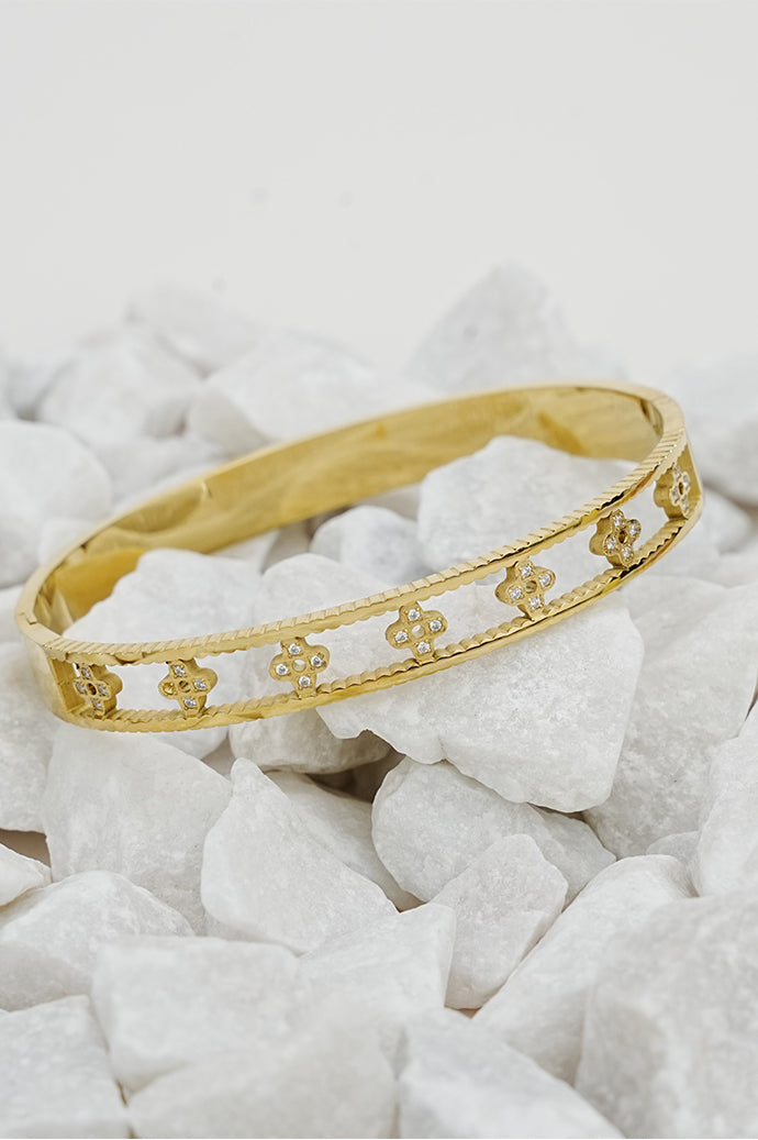 Gold open clove bangle with cut-out clove design on white stones