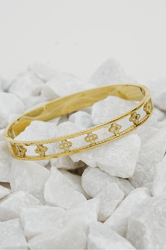 Gold open clove bangle with cut-out clove design on white stones