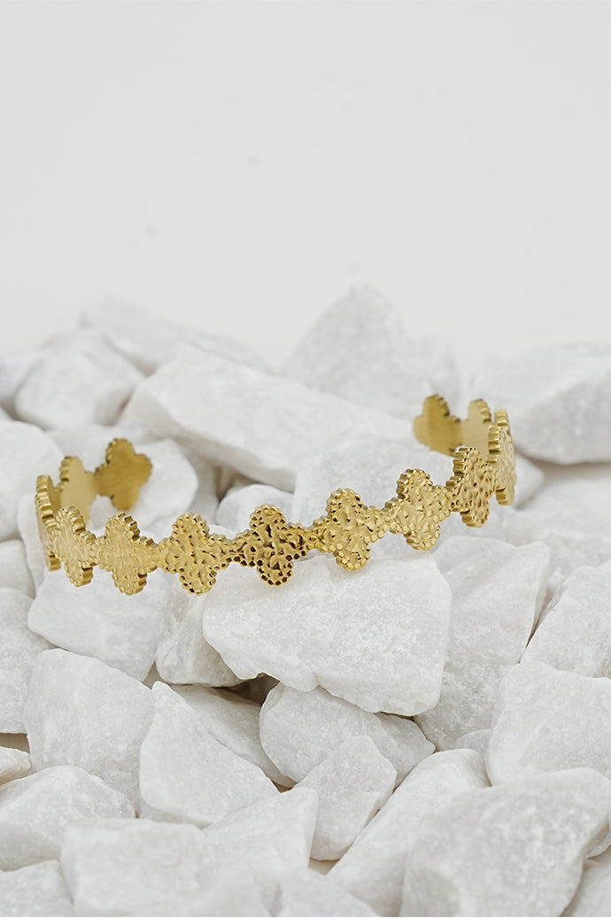 Gold open glazed bangle with scalloped edge on white stones