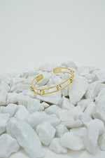 Gold open pearl bangle for women on white stones