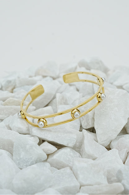 Gold open pearl bangle with double band design on white stones