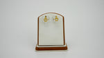 Gold pearl earrings on a display stand