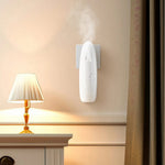 Plug-in aroma diffuser releasing mist from a bedroom wall socket beside a bed