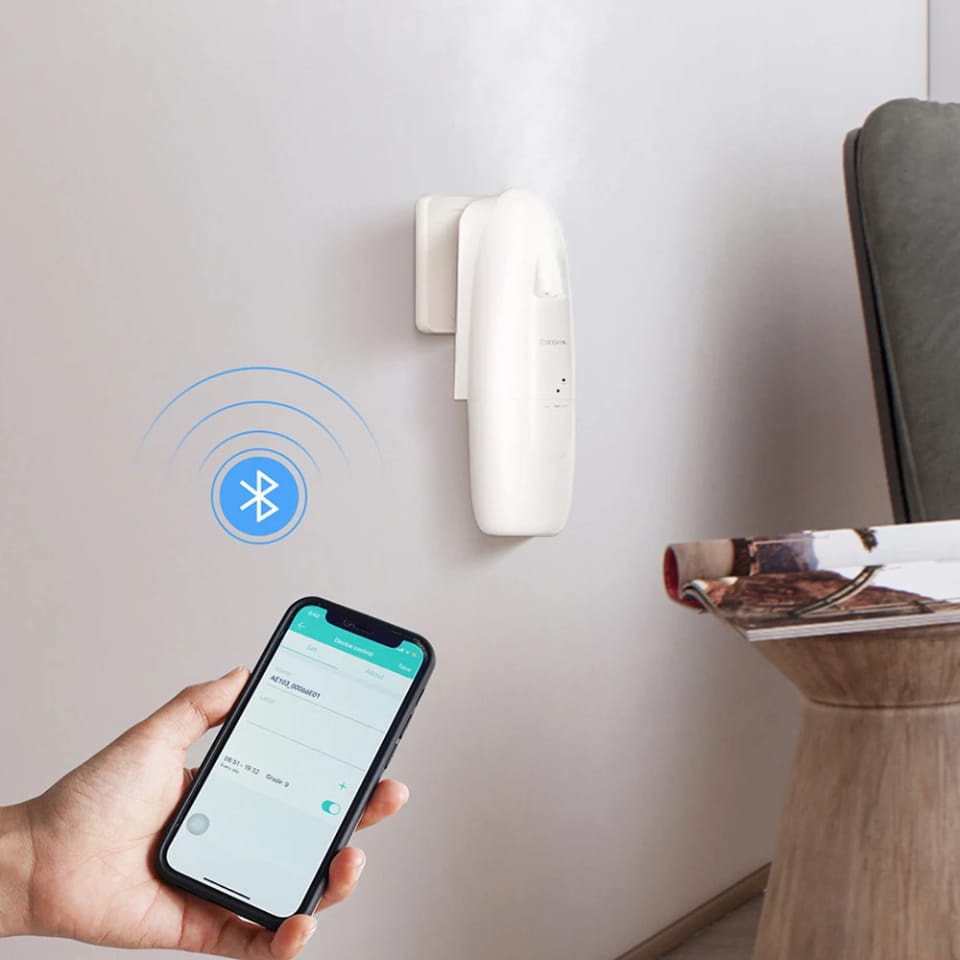 Plug-in aroma diffuser on a wall controlled by phone app over Bluetooth