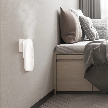 Plug-in aroma diffuser releasing mist on a living-room wall beside a table lamp