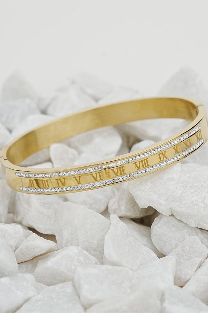 Gold Roman style rhinestone bangle for women on white stones