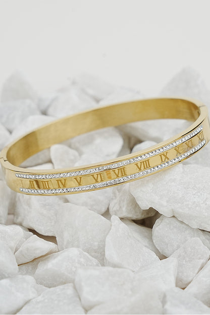 Gold Roman style rhinestone bangle for women on white stones