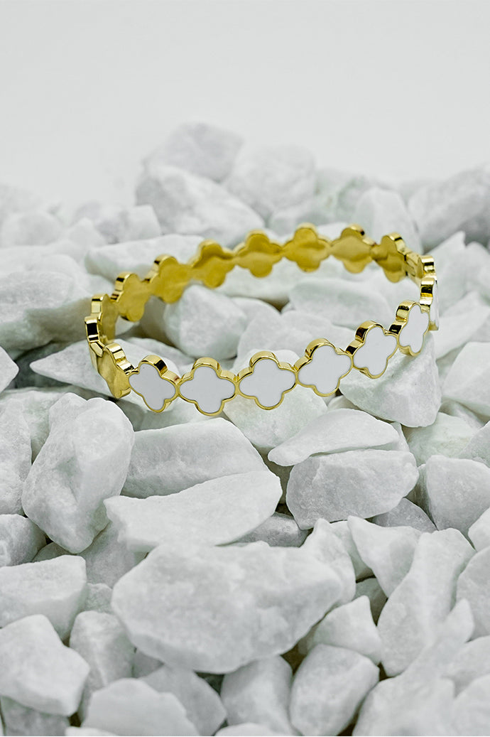 Top view of gold Roman style close bangle on white stones