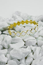 Top view of gold Roman style close bangle on white stones