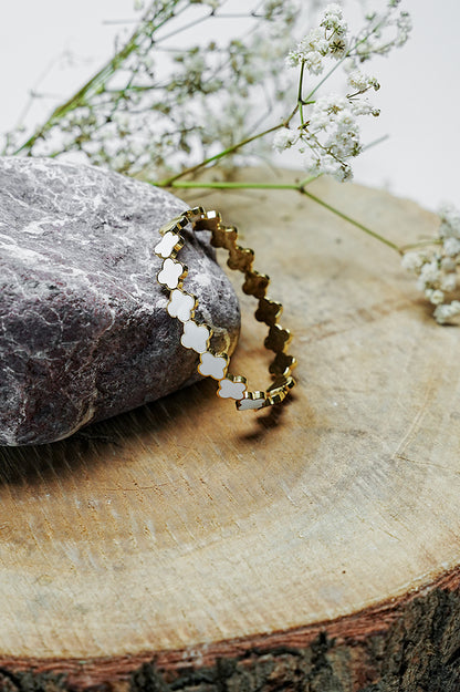 Side view of Roman style gold bangle with black clover pattern